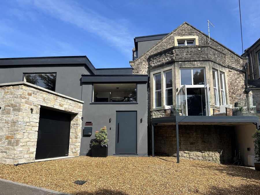 Period stone house with a contemporary rendered extension and integral garage